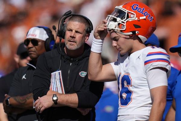 Florida head coach Billy Napier, left, talks with quarterback Aidan Warner, right, on the sidelines during the second half of an NCAA college football game against Texas in Austin, Texas, Saturday, Nov. 9, 2024. (AP Photo/Eric Gay)