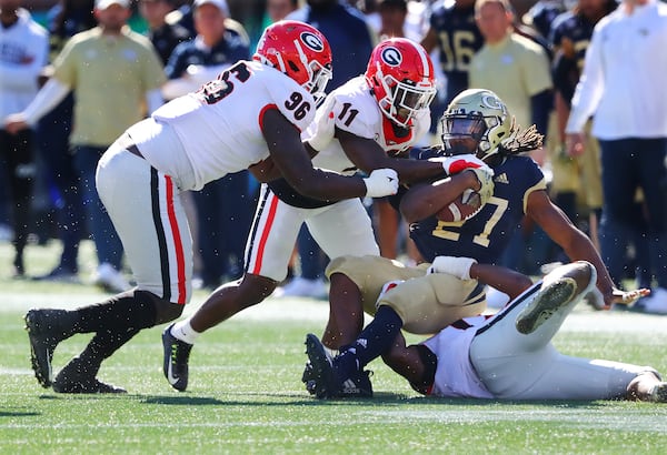 Georgia defensive lineman Zion Logue (from left) and defensive back Derion Kendrick tackle Georgia Tech running back Jordan Mason during the first half on the way to a 45-0 shut out in a NCAA college football game on Saturday, Nov. 27, 2021, in Atlanta.   “Curtis Compton / Curtis.Compton@ajc.com”`