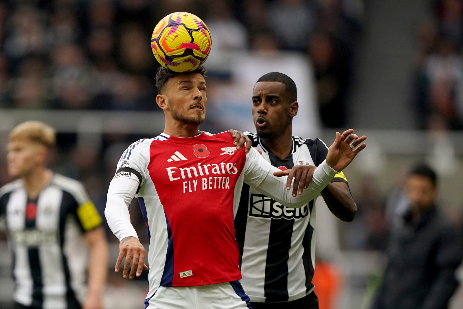 Arsenal's Ben White, left and Newcastle United's Alexander Isak vie for the ball, during the English Premier League soccer match between Newcastle United and Arsenal, at St James' Park, in Newcastle, England, Saturday, Nov. 2, 2024. (Owen Humphreys/PA via AP)