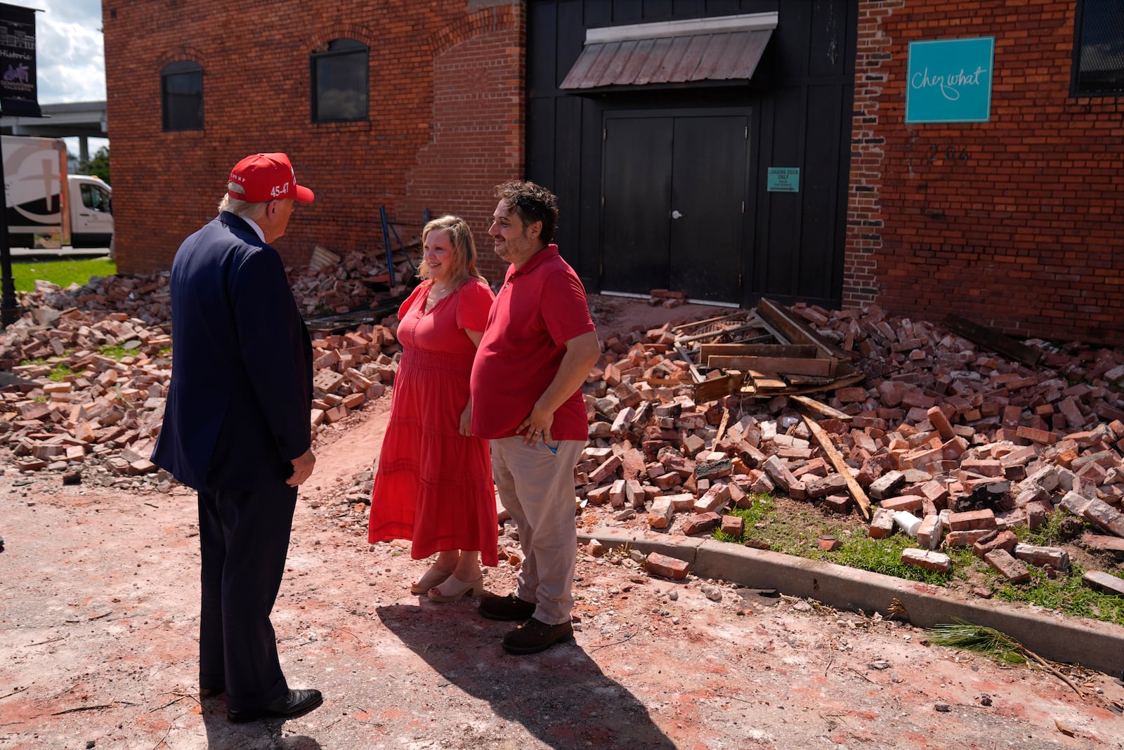 Republican presidential nominee former President Donald Trump talks with Chez What furniture store owners Katie and Patrick Watson as he visits Valdosta, Ga., a town impacted by Hurricane Helene, Monday, Sept. 30, 2024. (AP Photo/Evan Vucci)