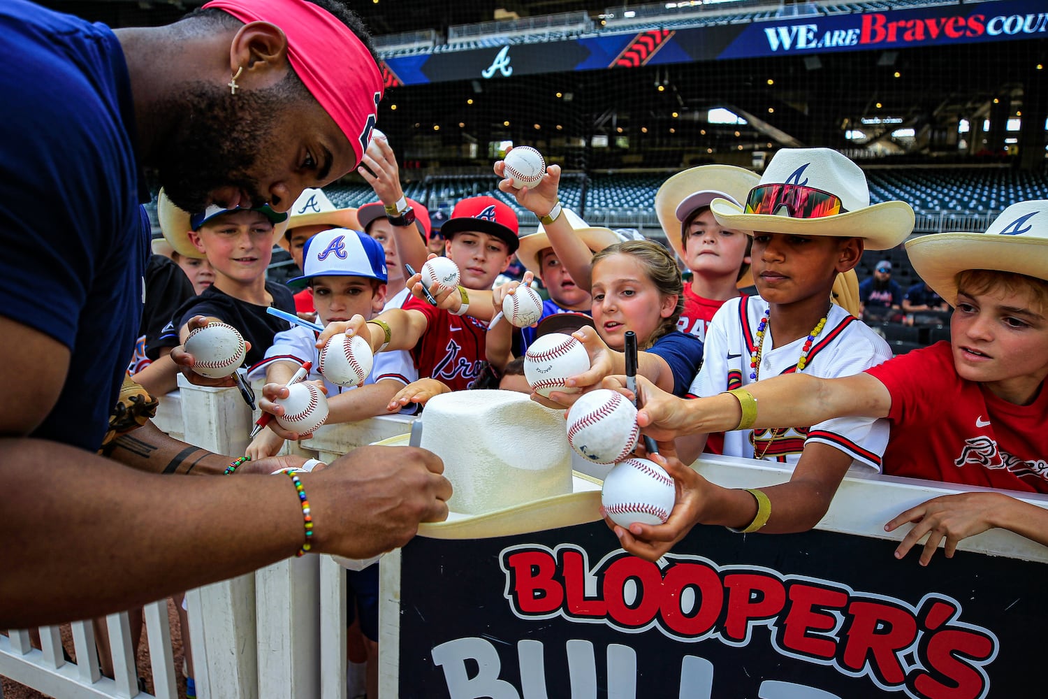 Tampa Bay Rays player Yandy Diaz signs a cowboy hat before the game at Truist Park in Atlanta, Georgia  on Friday, June 14, 2024.  The first 15,000 fans who entered the gate received a free Braves cowboy hat. (Ziyu Julian Zhu / AJC)