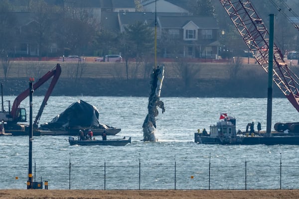 FILE - A piece of wreckage is lifted from the water onto a salvage vessel near the site in the Potomac River of a mid-air collision between an American Airlines jet and a Black Hawk helicopter, at Ronald Reagan Washington National Airport, Feb. 4, 2025, in Arlington, Va. (AP Photo/Ben Curtis, file)