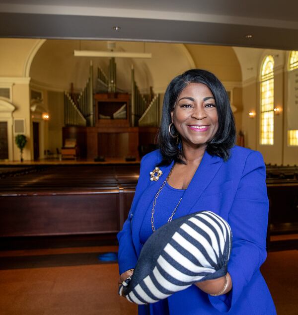 Dr. Angela Farris stands inside Spelman College's Sisters Chapel on Friday, June 14, 2024. When she was 10 years old, she attended her grandmother's wake in the chapel, after Alberta Williams King was assassinated while playing the organ at Ebenezer Baptist Church. She holds one of King’s hats and remembers the grandmother they called “Big Momma.”(Jenni Girtman for the AJC 2024)