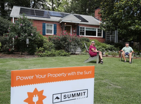 Patti and Gary Garrett, relaxing in their front yard, have 13 newly installed solar panels on the roof of their home on Tuesday July 14, 2020 in Decatur. CURTIS COMPTON / AJC