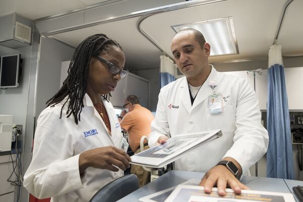 In this file photo, Grady Memorial Hospital chief of emergency medicine Dr. Hany Atallah (right) speaks with Sheryl Heron, vice chair of administrative affairs in the department of emergency medicine, inside Carolinas MED-1, a mobile medical facility located outside of the Marcus trauma and emergency room at Grady. ALYSSA POINTER / ALYSSA.POINTER@AJC.COM