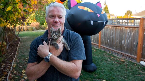 Chuck Hawley poses with his new kitten, Sticky, on Tuesday, Oct. 22, 2018 in Silverton, Ore. Hawley found Sticky glued to the side of the road and took her in.