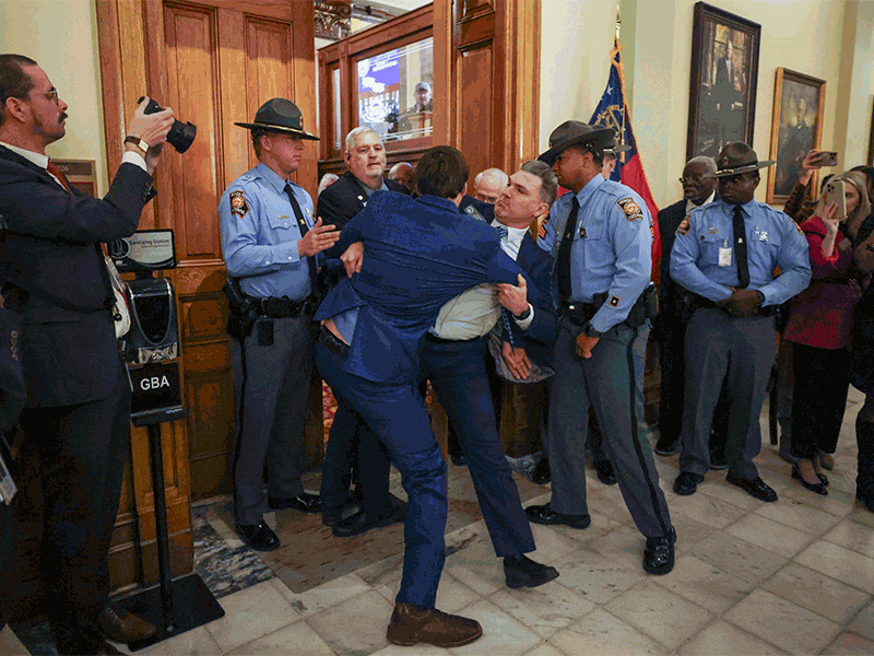 Sen. Colton Moore, R-Trenton, falls to the ground after he scuffled with a staff member as he attempts to enter the state House of Representatives for the State of the State address at the Georgia Capitol, Thursday, Jan. 16, 2025, in Atlanta. Georgia State Patrol and staff detained Sen. Moore for attempting to enter the state House of Representatives. Moore was banned from the House last year after comments he made about the late House Speaker David Ralston. (Jason Getz / AJC)