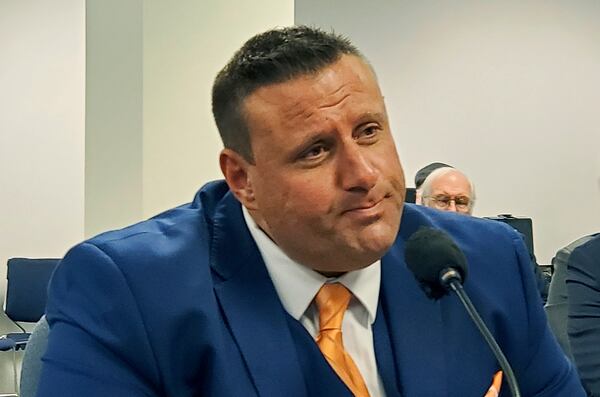 T.J. Abraham testifies during a New York state assembly hearing Tuesday, Oct. 29 in New York. The 42-year-old doctor testified about the brain damage that forced him to stop his medical practice and urged New York state legislators to pass a law banning tackle football for children under 13.