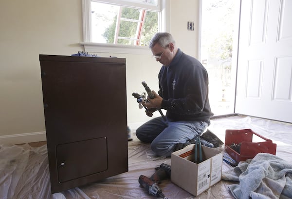 Plumber David Murphy works in an East Wareham, Massachusetts home in 2014. Doctors and researchers say that during the pandemic it’s important for home repair people and installers to work in well-ventilated areas and to wear masks at all times. Homeowners and workers should maintain social distance throughout the visit. STEPHAN SAVOIA/ASSOCIATED PRESS