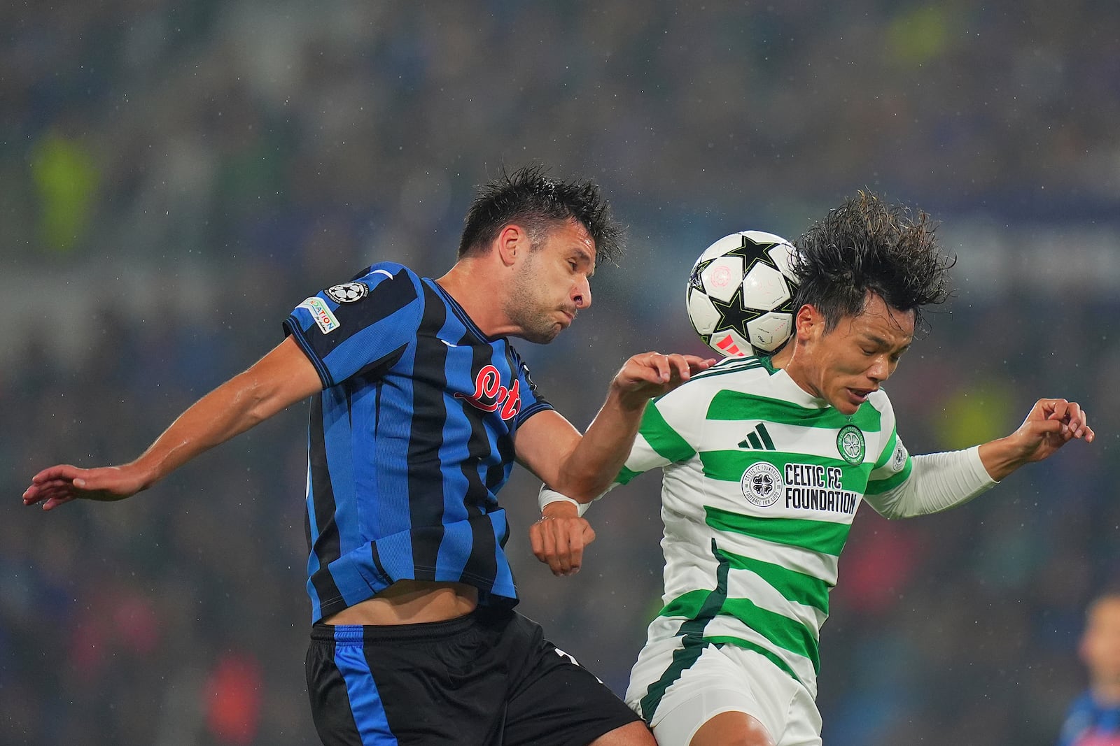 Atalanta's Berat Djimsiti, left, and Celtic's Reo Hatate battle for a head ball during the Champions League soccer match between Atalanta BC and Celtic FC at Gewiss Stadium in Bergamo, Italy, Wednesday Oct. 23, 2024. (Spada/LaPresse via AP)