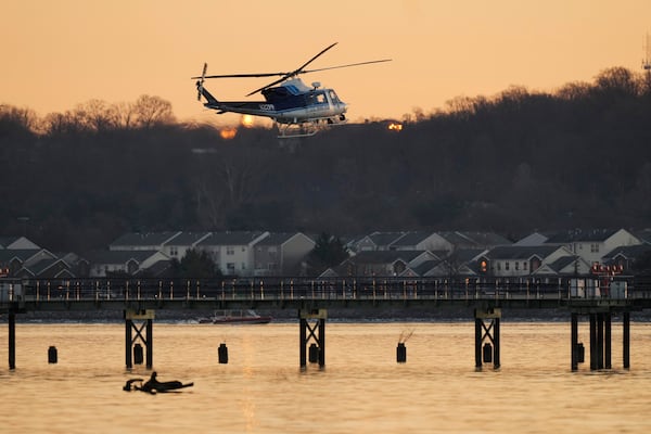 A US Park Police helicopter flies over the Potomac River near Ronald Reagan Washington National Airport, Thursday, Jan. 30, 2025, in Arlington, Va. (AP Photo/Carolyn Kaster)