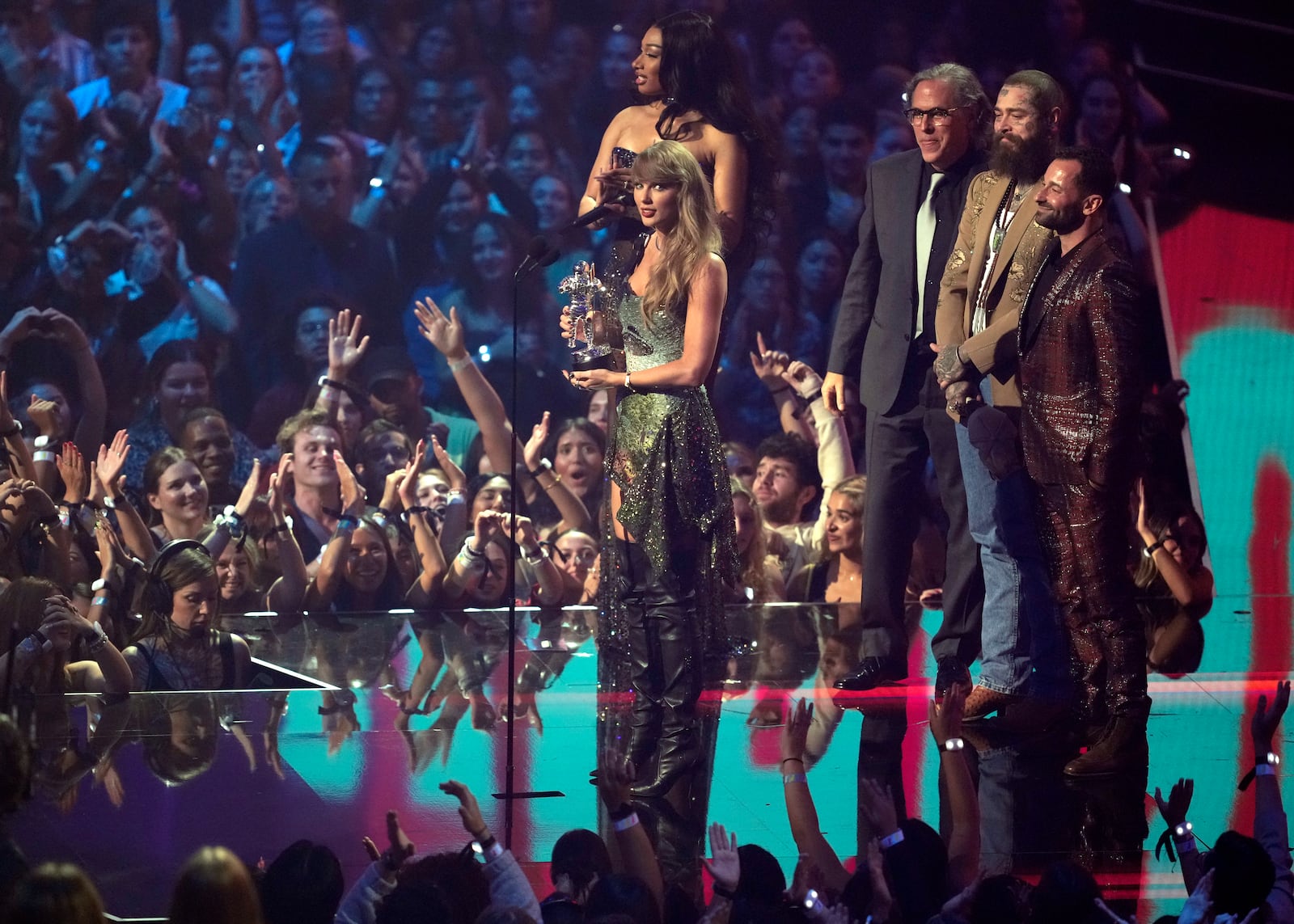 Taylor Swift, center, and Post Malone, third from back left, accept the video of the year award for "Fortnight" during the MTV Video Music Awards on Wednesday, Sept. 11, 2024, at UBS Arena in Elmont, N.Y. Host Megan Thee Stallion, from far left back, Rodrigo Prieto, and Ethan Tobman, far right, look on. (Photo by Charles Sykes/Invision/AP)