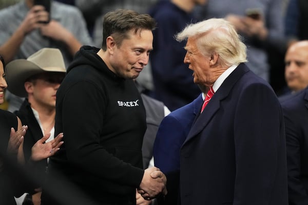 Elon Musk, left, shakes hands with President Donald Trump at the finals for the NCAA wrestling championship, Saturday, March 22, 2025, in Philadelphia. (AP Photo/Matt Rourke)