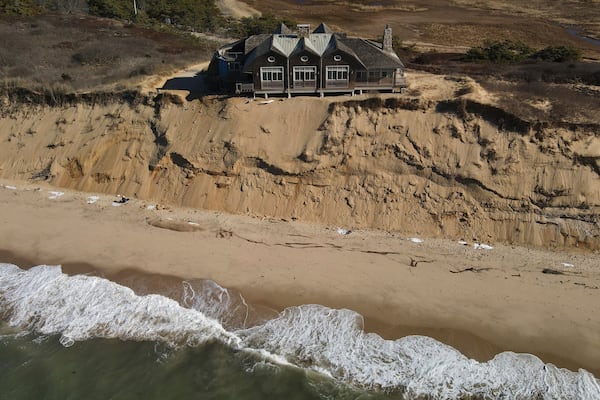 FILE - A home sits atop of a sandy bluff overlooking a beach in Wellfleet, Mass., Jan. 27, 2025. (AP Photo/Andre Muggiati, File)