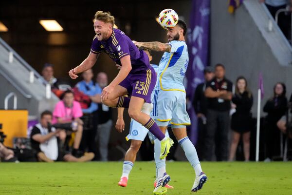 Atlanta United's Derrick Williams, right, gives Orlando City's Duncan McGuire (13) a push to get control of a head ball during the second half of an MLS Semifinal Conference playoff soccer match, Sunday, Nov. 24, 2024, in Orlando, Fla. (AP Photo/John Raoux)