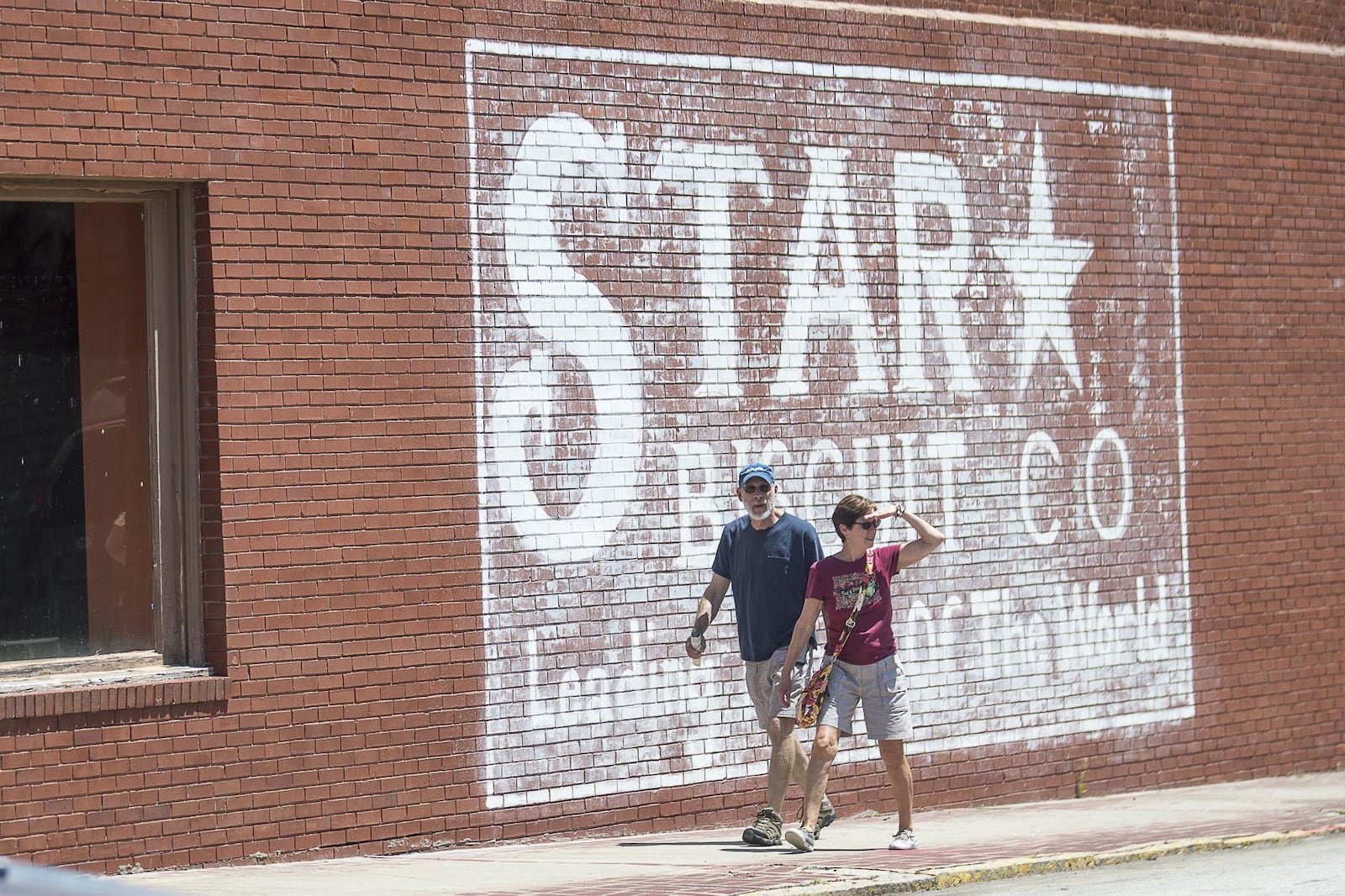 People walk by a building in downtown Stone Mountain. (ALYSSA POINTER/ALYSSA.POINTER@AJC.COM)