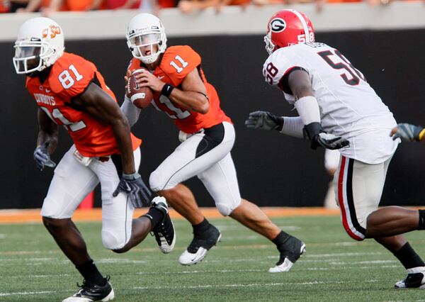 Oklahoma State quarterback Zac Robinson (11) is flushed out of the pocket by Georgia's Demarcus Dobbs.