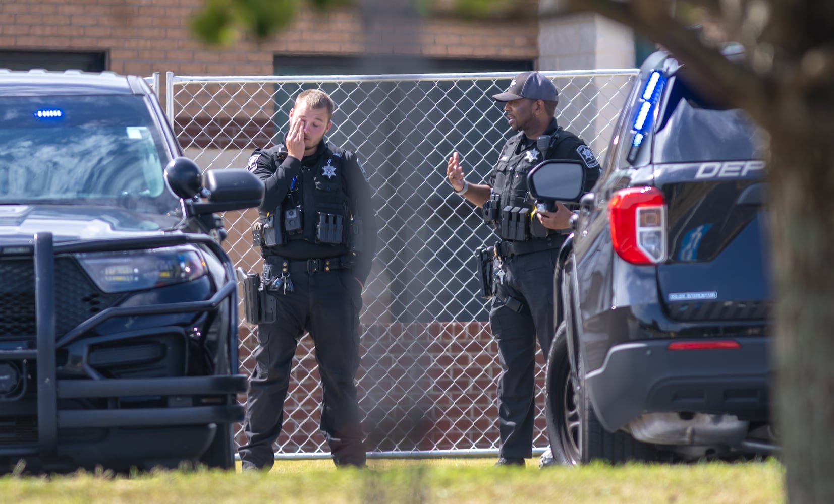 Barrow County law enforcement were posted outside the now fenced-in school. Students and well wishers arrived with flowers to place at the flag pole at Apalachee High School in Winder on Thursday, Sept. 5, 2024. A 14-year-old is accused of shooting and killing two fellow students and two teachers and injuring nine others at Apalachee High School on Wednesday. (John Spink/AJC)