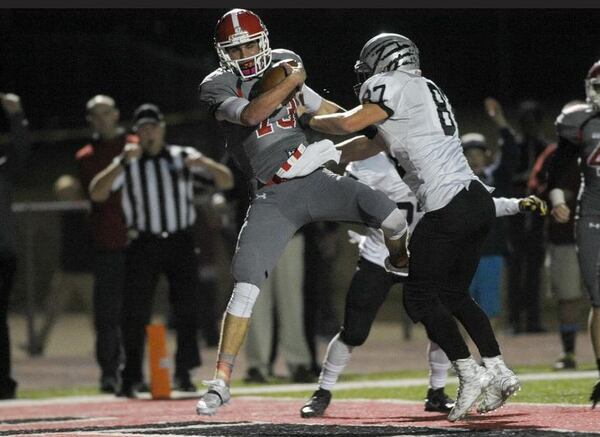 Acworth, Ga. -- Altoona senior quarterback Brandon Rainey (13) stumbles into the end zone for a touch down in the first half of play as Houston County senior defensive end Salomon Raas (87) defends in the third round of football playoffs Friday, November 27, 2015. SPECIAL/DANIEL VARNADO