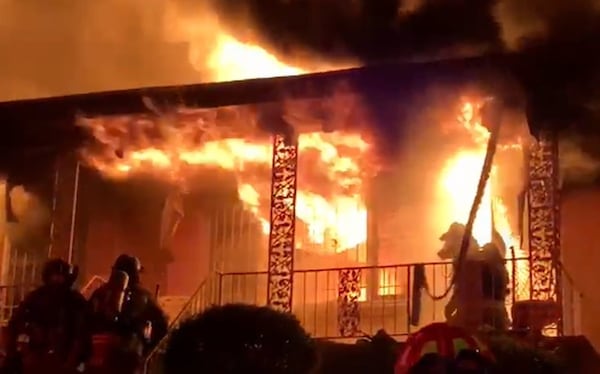 Atlanta fire Capt. Danny Dwyer kneels on the porch after pulling 94-year-old Sallie Skrine from her home. 