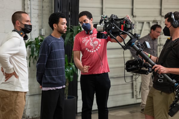 (L to R) Director of photography Doug Emmett, actor Justice Smith and writer/director Kobi Libii on the set of "The American Society of Magical Negroes." (Tobin Yelland/Focus Features)