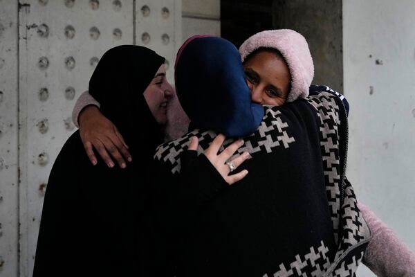 People hug each other upon their arrival at their neighborhood as they celebrate a ceasefire between Hezbollah and Israel, which began early morning, in Tyre, south Lebanon, Wednesday, Nov. 27, 2024. (AP Photo/Hussein Malla)