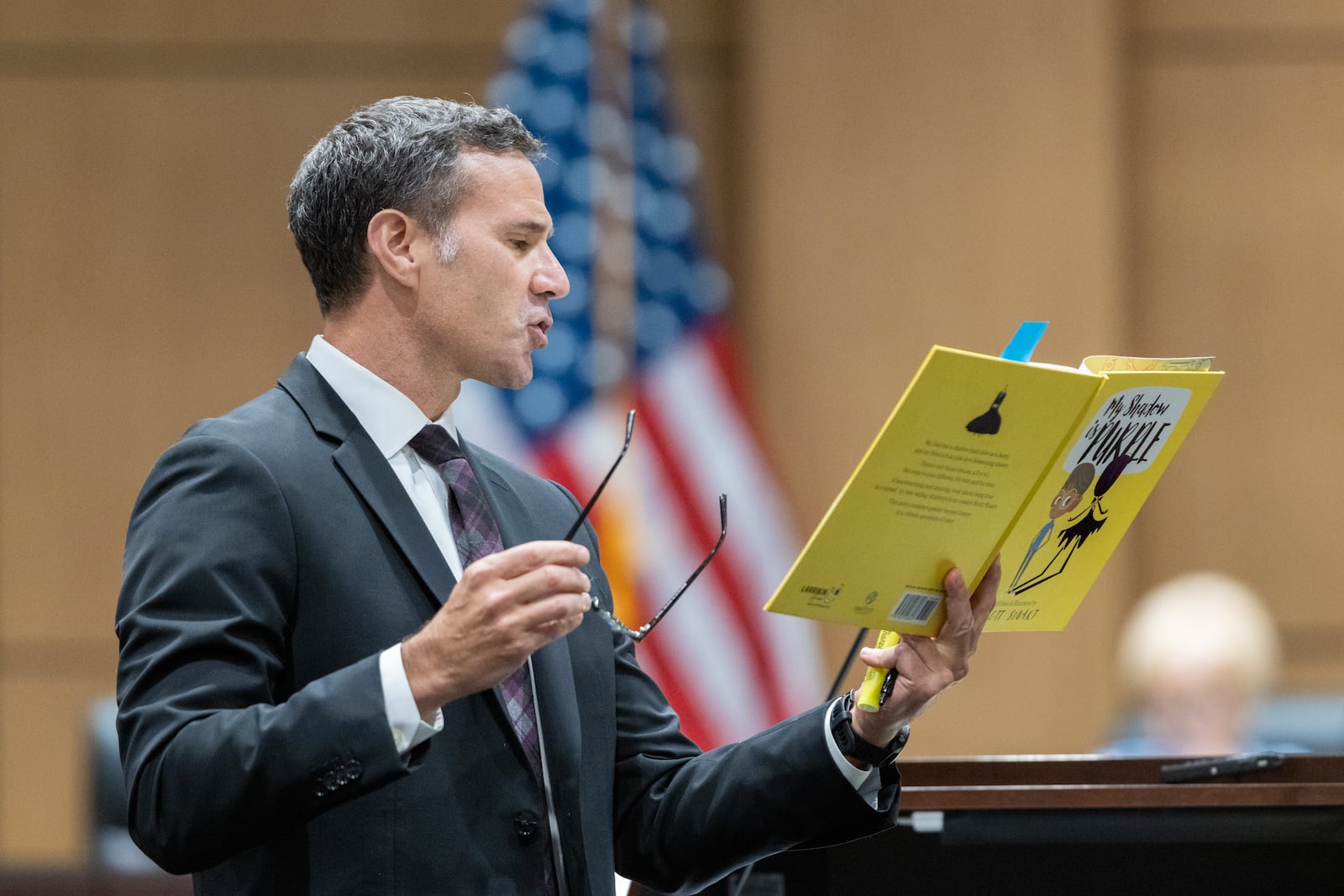 Cobb County teacher Katie Rinderle’s attorney Craig Goodmark reads from a copy of children’s book “My Shadow is Purple” at a hearing at the Cobb County Board of Education in Marietta on Thursday, August 10, 2023. Rinderle is facing termination after reading “My Shadow is Purple,” a book about gender identity, to fifth graders. (Arvin Temkar / arvin.temkar@ajc.com)