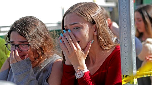 Students released from a lockdown are overcome with emotion following following a shooting at Marjory Stoneman Douglas High School in Parkland, Fla., Wednesday, Feb. 14, 2018. (John McCall/South Florida Sun-Sentinel via AP)