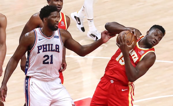 Hawks center Clint Capela grabs the defensive rebound away from Philadelphia 76ers center Joel Embiid during Game 3 of the Eastern Conference Semifinals Friday, June 11, 2021, at State Farm in Atlanta. (Curtis Compton / Curtis.Compton@ajc.com)