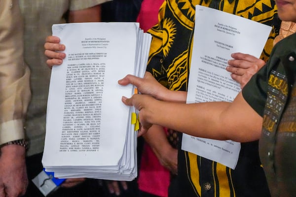 Activists hold a copy of a second impeachment complaint filed against Philippine Vice President Sara Duterte on Wednesday Dec. 4, 2024 at the House of Representatives in Quezon City, Philippines. (AP Photo/Aaron Favila)