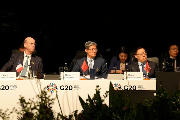 French Finance Minister Eric Lombard, left, with Xuan Changneng, Deputy Governor with the People's Bank of China, center, attend the G20 Finance Ministers and Central Bank Governors meeting in Cape Town, South Africa, Wednesday, Feb. 26, 2025. (AP Photo/Nardus Engelbrecht)