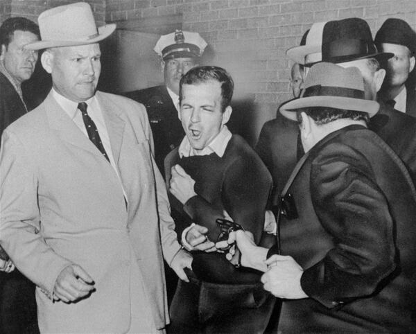 Lee Harvey Oswald, suspected assassin of President John F. Kennedy, reacts as Dallas night club owner Jack Ruby, foreground, shoots at him from point-blank range in a corridor of Dallas police headquarters. At left is Detective Jim Leavelle. Leavelle wanted to secretly take Oswald out the side door of Dallas police headquarters on that day forty-five years ago. His boss wanted to keep a promise to reporters. So Leavelle handcuffed himself to President Kennedy's assassin, stepped into a crowded basement and became an accidental part of history. (AP Photo/Dallas Times-Herald, Bob Jackson)