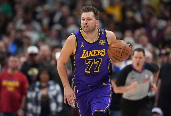 Los Angeles Lakers guard Luka Doncic brings the ball up the court against the Denver Nuggets in the first half of an NBA basketball game Saturday, Feb. 22, 2025, in Denver. (AP Photo/David Zalubowski)