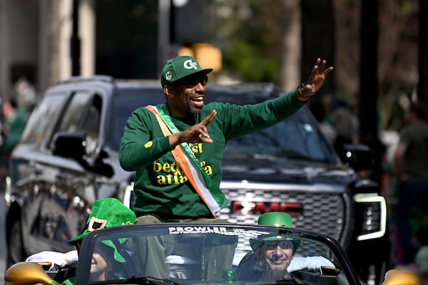 Atlanta Mayor Andre Dickens waves as the floats head down Peachtree Street during the Atlanta St. Patrick's Parade, Saturday, March 15, 2025, in Atlanta. The parade begins at noon at the corner of 15th and Peachtree streets and will continue south along Peachtree to 5th Street. Everyone is encouraged to be Irish for the day as they watch the parade, which is filled with floats, bands, bagpipe and drum corps, dancers, clowns, drill teams and more. (Hyosub Shin / AJC)