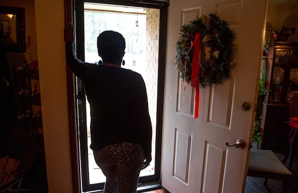 A client of the federal Housing Opportunities for Persons with AIDS program looks out the front door of the Ellenwood house where she was staying on Sunday, December 23, 2021.  She is homeless after her case fell through the cracks of the city of Atlanta-run program. STEVE SCHAEFER FOR THE ATLANTA JOURNAL-CONSTITUTION