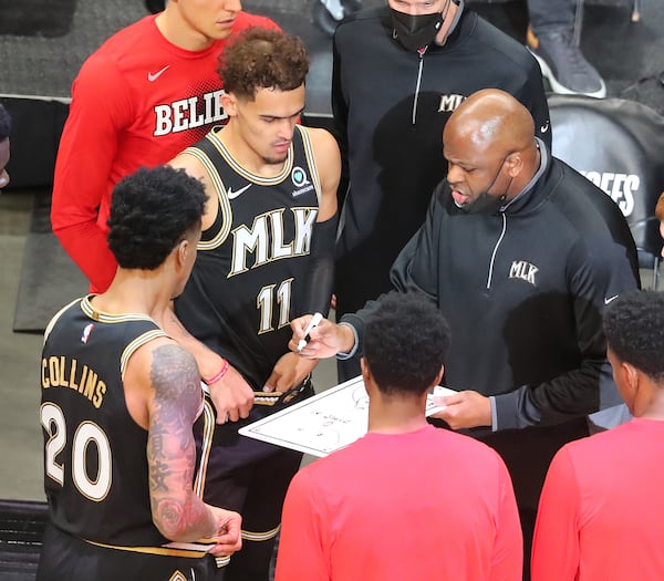 Hawks players John Collins and Trae Young look on as interim head coach Nate McMillan works up a play during the 113-96 Game 4 win over the New York Knicks in their first-round NBA playoff series Sunday, May 30, 2021, at State Farm Arena in Atlanta. (Curtis Compton / Curtis.Compton@ajc.com)