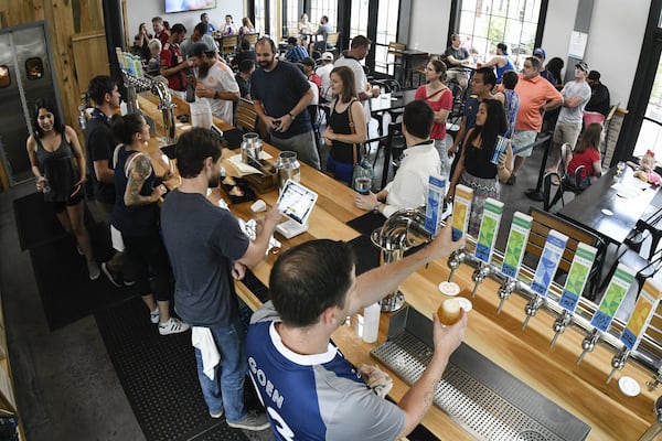 Bartender Jimmy Goen (right) pours beer from a tap at Variant Brewing in Roswell earlier this month. Variant has more than 15 beers on draft in half or full pours and crowlers to go. CONTRIBUTED BY JOHN AMIS