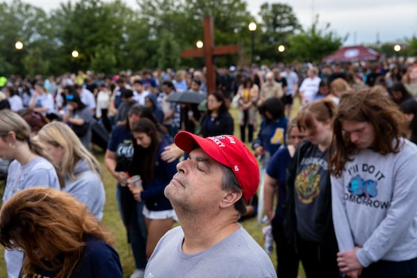 Mourners pray at a vigil at Jug Tavern Park in Winder on Friday, Sept. 6, 2024. A 14-year-old Apalachee High School student is accused of shooting and killing four and injuring nine others at the Barrow County high school on Wednesday.