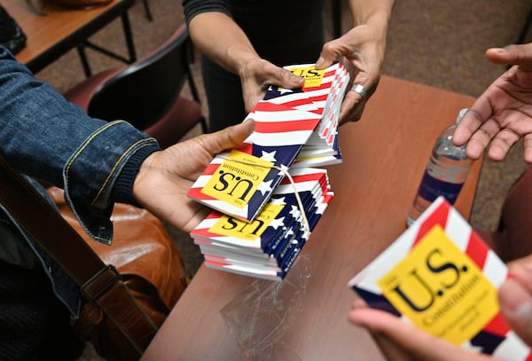 Students receive U.S. Constitution handbooks during Adrienne Jones’ constitutional law class at Morehouse College on Tuesday, Feb. 8, 2022. (Hyosub Shin / Hyosub.Shin@ajc.com)