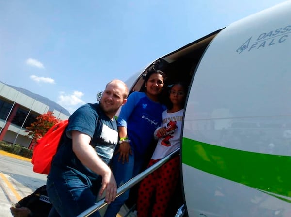 In this image provided by the Holt family, Joshua Holt, his wife Thamara and her daughter Marian Leal, board a plane at the airport in Caracas, Venezuela, Saturday, May 26, 2018.  Jailed in Venezuela on weapons charges nearly two years ago, Holt was released Saturday after a U.S. senator pressed for his freedom in a surprise meeting with President Nicolas Maduro. Holt and his wife, who also jailed, were reunited with her daughter from a previous relationship at Caracas airport where the three boarded a chartered flight to Washington. (Holt family photo via AP)