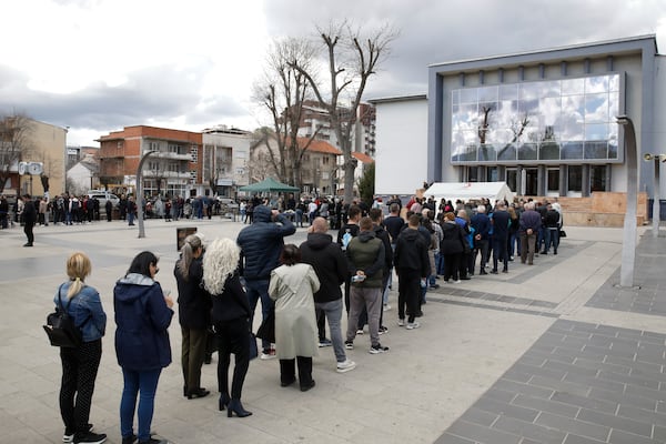 People wait in line to write condolence messages for the victims of a massive nightclub fire in the town of Kocani, North Macedonia, Monday, March 17, 2025. (AP Photo/Boris Grdanoski)