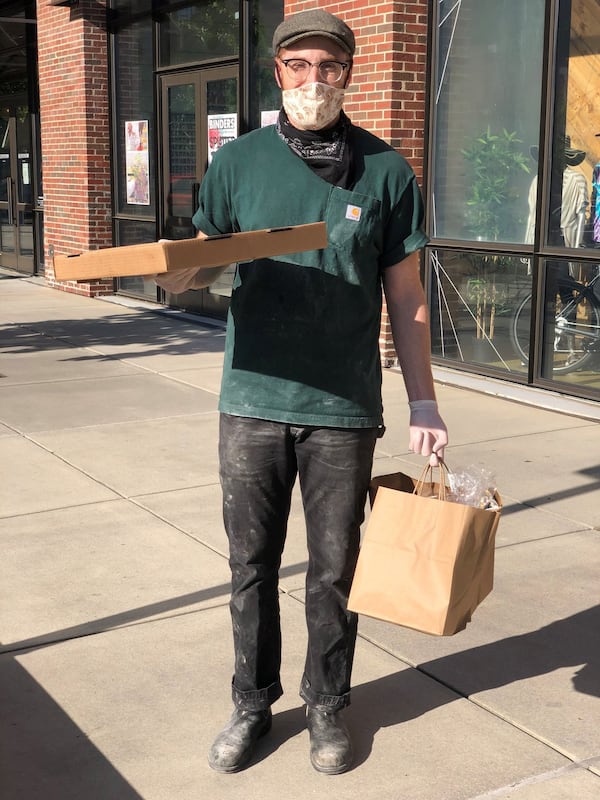 Chris Wilkins of Pizza Jeans brings an order to the curbside at Ponce City Market. CONTRIBUTED BY WENDELL BROCK