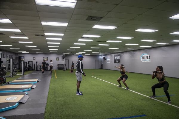 Damion “Stick” Harrell (center), fitness trainer at E.F.F.E.C.T. Fitness, works with two clients at the fitness center in Atlanta’s Sylvan Hills community, Friday, June 12, 2020. During the lunchtime boot camp, the gym usually hosts more than 50 attendees. Photo: ALYSSA POINTER / ALYSSA.POINTER@AJC.COM