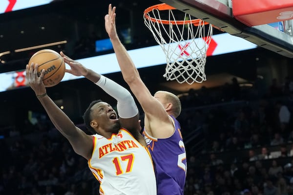 Atlanta Hawks forward Onyeka Okongwu (17) drives past Phoenix Suns center Mason Plumlee , right, to score during the first half of an NBA basketball game Thursday, Jan. 9, 2025, in Phoenix. (AP Photo/Ross D. Franklin)