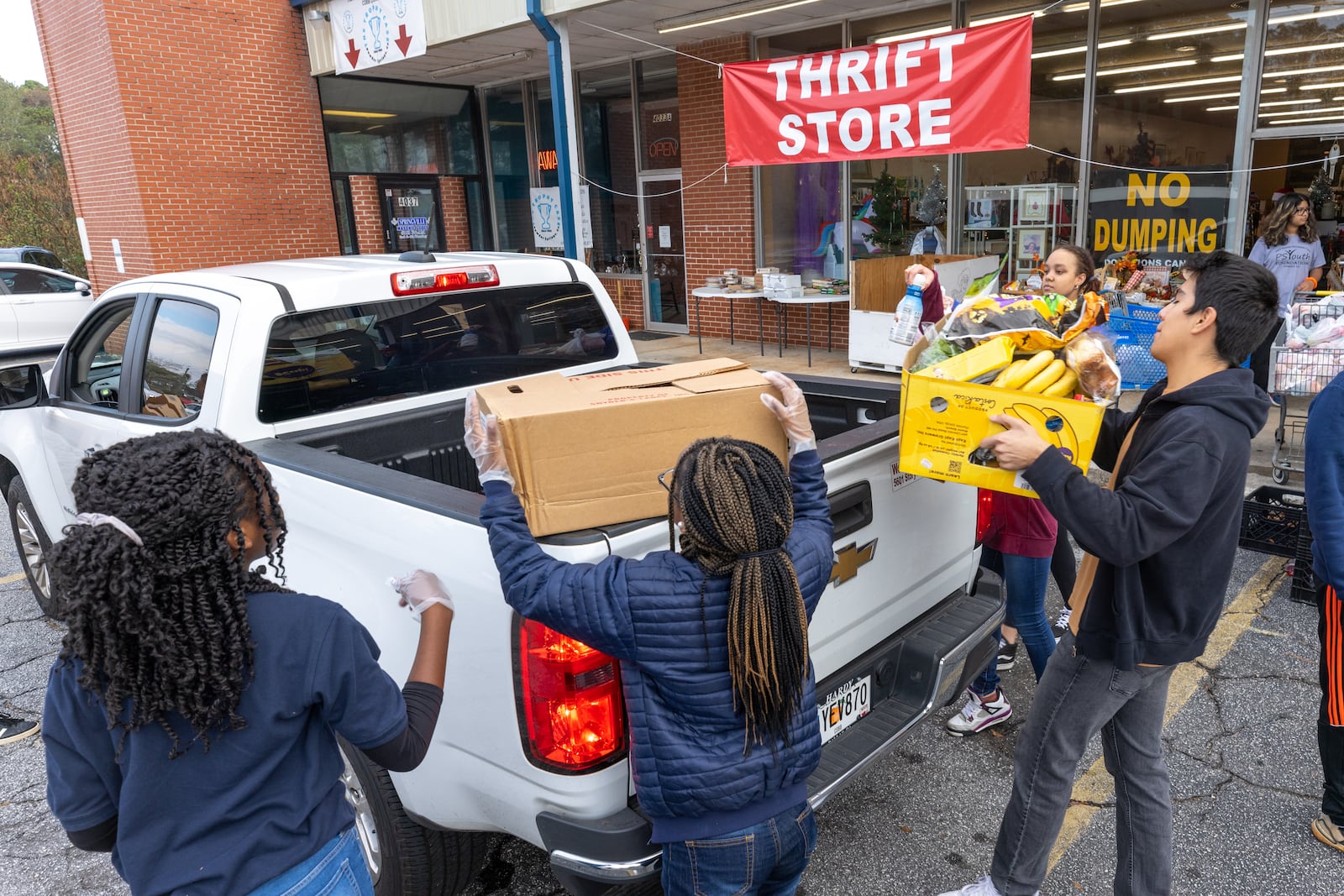 Volunteers load food into a truck during the Reflections of Trinity weekly food distribution in Powder Springs on Saturday, Nov. 12, 2022. (Photo: Steve Schaefer / steve.schaefer@ajc.com)