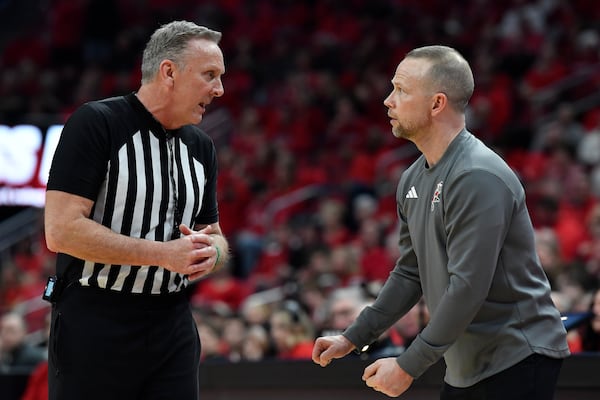 Louisville head coach Pat Kelsey, right, talks with a game official during the first half of an NCAA college basketball game against Stanford in Louisville, Ky., Saturday, March 8, 2025. (AP Photo/Timothy D. Easley)