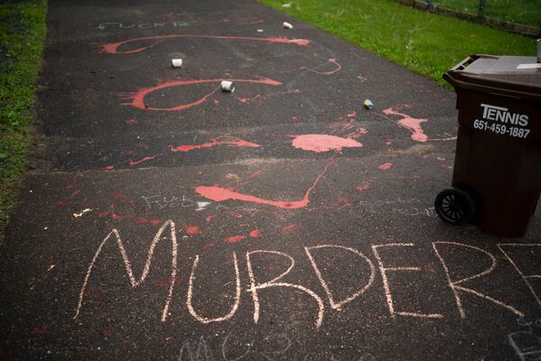 Splattered paint and chalk writing are on the driveway of the home of fired Minneapolis police Officer Derek Chauvin.