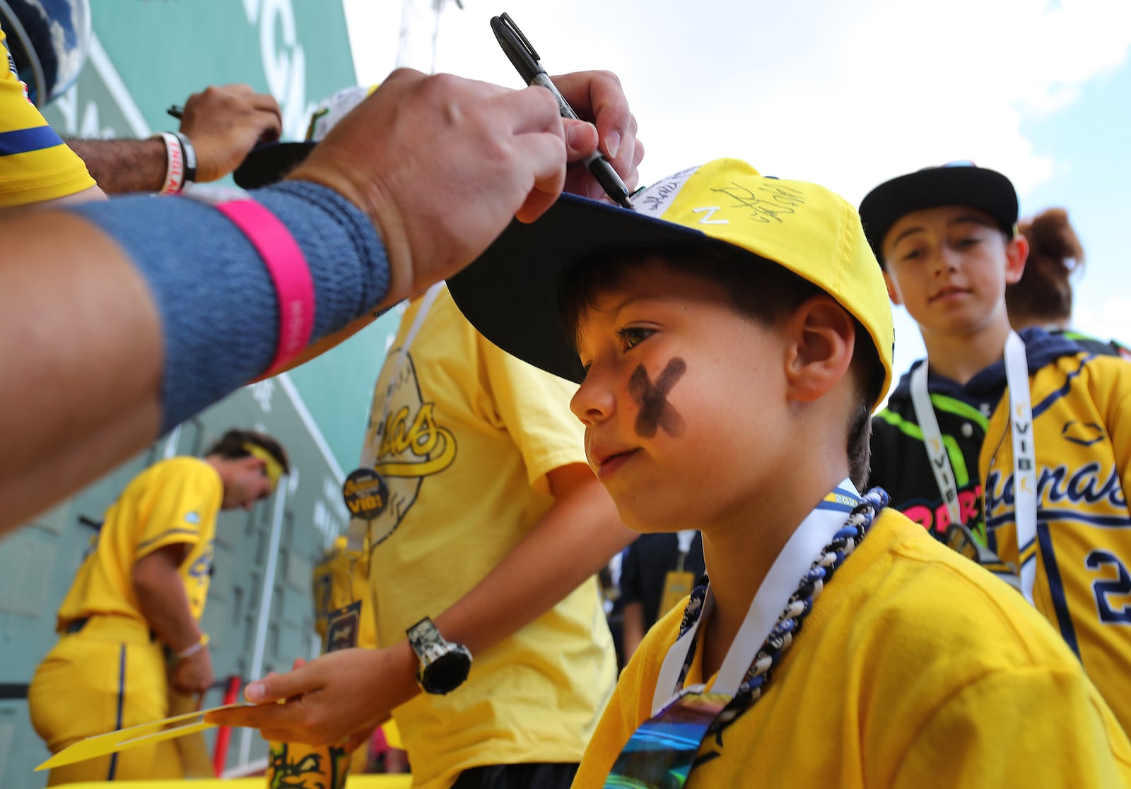 Coen Hosford, 8, gets his hat autographed in the outfield before the game. The Savannah Bananas took their World Tour to a sold-out Fenway Park on Saturday, June 8, 2024, as they played the Party Animals before over 37,000 fans in Boston. (John Tlumacki/The Boston Globe)