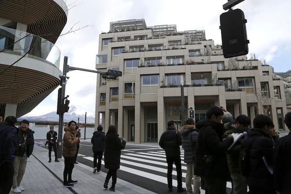 Reports see the apartment complexes and the roads where a mobility will be tested at Toyota’s Woven City during a tour in Susono, Shizuoka prefecture, Saturday, Feb. 22, 2025. (AP Photo/Yuri Kageyama)