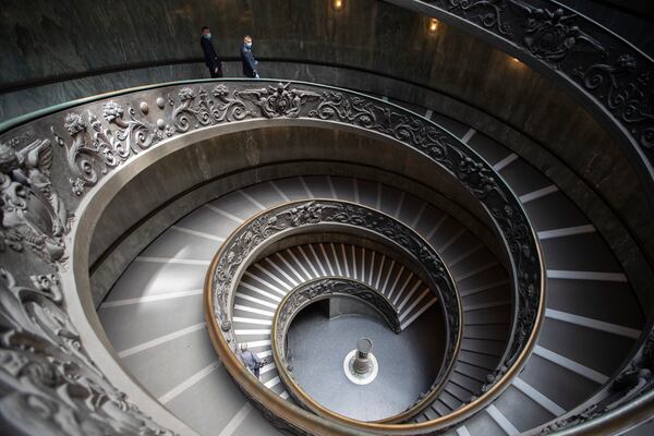 Museum employees, wearing masks to prevent the spread of coronavirus, walk down a staircase as the Vatican Museum reopened Monday in Rome.